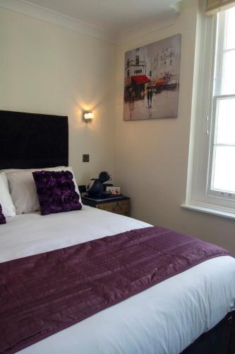 a bedroom with a large bed with a purple blanket at The Ship Leopard Hotel - No Children in Portsmouth