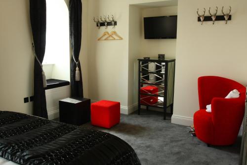 a bedroom with two red chairs and a tv at The Ship Leopard Hotel - No Children in Portsmouth