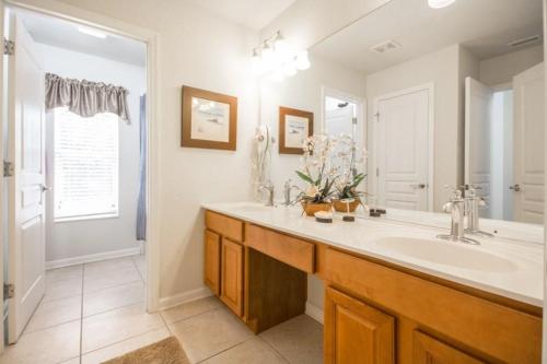 a bathroom with a sink and a large mirror at Mark's Windsor Hills Vacation Home in Orlando