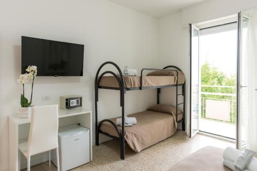 una camera da letto con due letti a castello e una televisione di Hotel Ninfea Cattolica a Cattolica