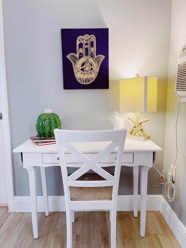 a white desk with a chair in a room at Sea Steps By Lowkl in Pompano Beach