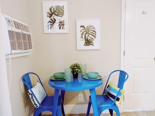 a blue table and two chairs in a room at Sea Steps By Lowkl in Pompano Beach