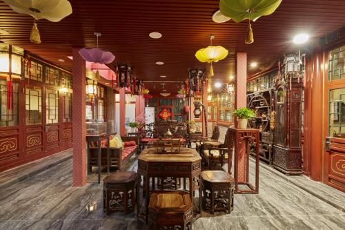 restauracja ze stołami i krzesłami w pokoju w obiekcie Beijing Rong Courtyard Boutique Hotel w Pekinie