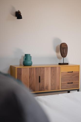 a wooden cabinet with a lamp on top of it at Hôtel-Restaurant Villa Métis in Les Herbiers