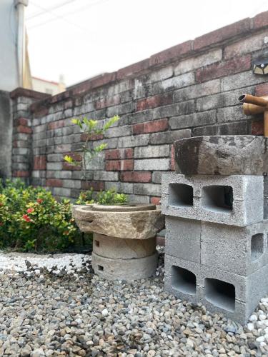 a stone bird bath sitting next to a brick wall at 北斗合法古厝民宿 in Beidou