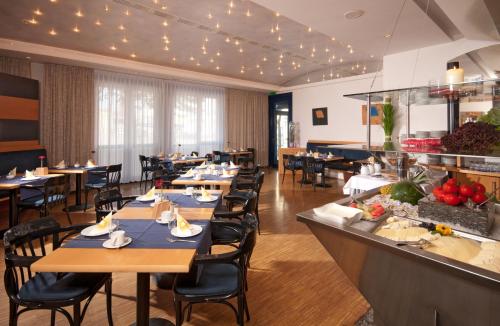 ein Restaurant mit Tischen und Stühlen und einem Buffet in der Unterkunft SEEhotel Friedrichshafen in Friedrichshafen