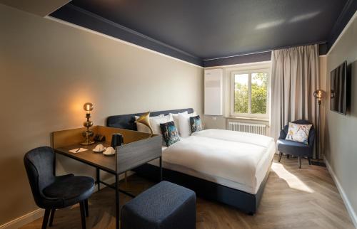 a bedroom with a bed and a desk and a chair at Maison Viktoria Augsburg in Augsburg
