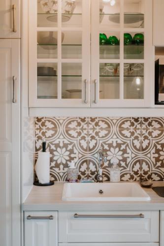 une cuisine avec des armoires blanches et un évier dans l'établissement Bord de mer C.L.S Deauville, à Benerville-sur-Mer