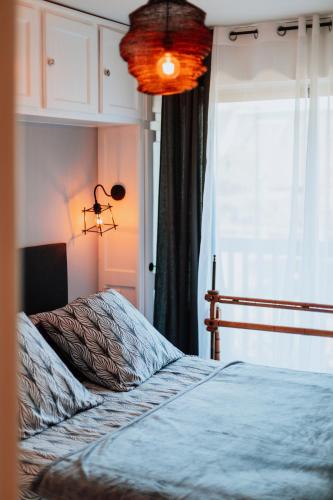 une chambre avec un lit et une fenêtre dans l'établissement Bord de mer C.L.S Deauville, à Benerville-sur-Mer