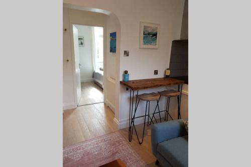een woonkamer met een tafel en een blauwe bank bij St Ives self catering apartment private parking near beaches in St Ives