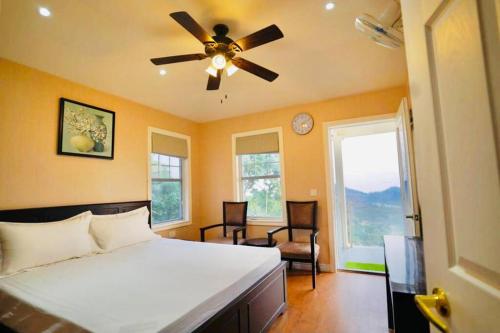 a bedroom with a bed and a ceiling fan at Le Reve Valley - Canadian cottage 2 - 3BHK Luxury cottage,Bonfire,Barbeque,Gym,Kids play zone,Lake view in Bhīm Tāl