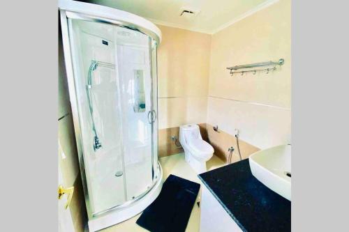 a bathroom with a shower and a sink and a toilet at Le Reve Valley - Canadian cottage 2 - 3BHK Luxury cottage,Bonfire,Barbeque,Gym,Kids play zone,Lake view in Bhīm Tāl