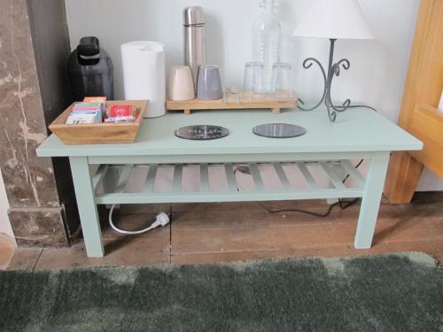 une console bleue avec une lampe dessus dans l'établissement ChezLola, à Civray