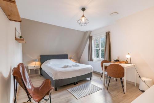 a bedroom with a bed and a table and chairs at De Hoogmolen - 3 mins from the city centre in Bruges