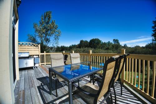 a patio with a table and chairs on a deck at Aiglon by Rendez-Vous Mont-Tremblant in Mont-Tremblant