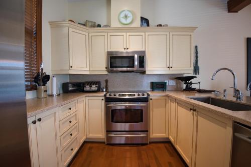 a kitchen with white cabinets and a stainless steel oven at Aiglon by Rendez-Vous Mont-Tremblant in Mont-Tremblant