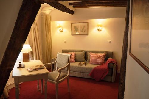 a living room with a couch and a table at Hôtel du Cygne Paris in Paris