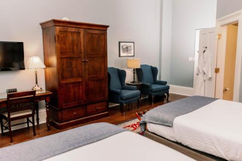 a bedroom with a bed and a dresser and a desk at The Marshall House, Historic Inns of Savannah Collection in Savannah