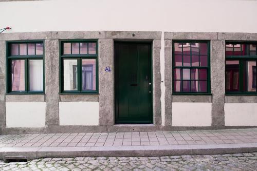 un edificio con una porta verde e quattro finestre di OportoLuxApartments a Porto