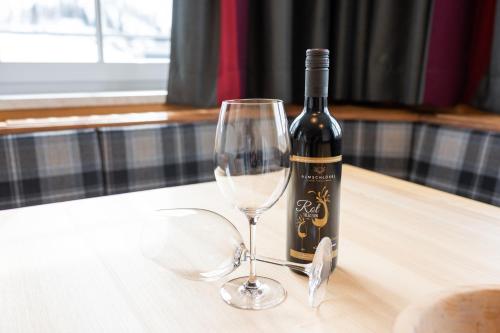 a bottle of wine sitting on a table with a glass at Hotel Almschlössl & Schrotteralm in Obertauern