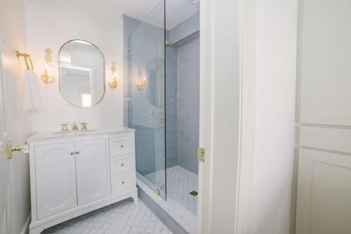 a white bathroom with a shower and a sink at Guesthouse Charleston EAST 42 B in Charleston