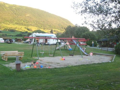 a small child's playground with a wooden bench at Smegarden Camping in Oppdal