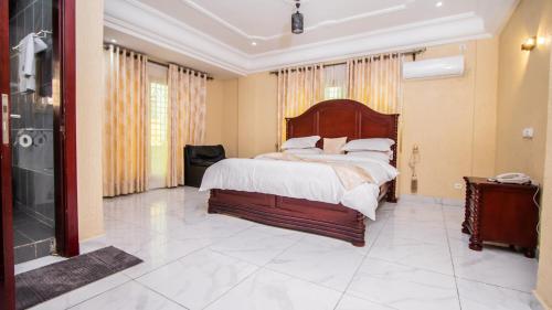 een slaapkamer met een groot bed en een inloopdouche bij Residence Le Bonheur - 2 Bed Apartment by Douala Mall/Airport in Douala