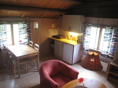 a kitchen and dining room with a table and a chair at Smegarden Camping in Oppdal