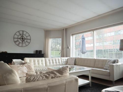 een woonkamer met een witte bank en een tafel bij Luxury Villa in Helmond with a Private Pool in Helmond