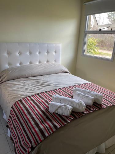a bed with two towels on it with a window at Princesas Del Mar a 4 cuadras del mar in Mar Azul