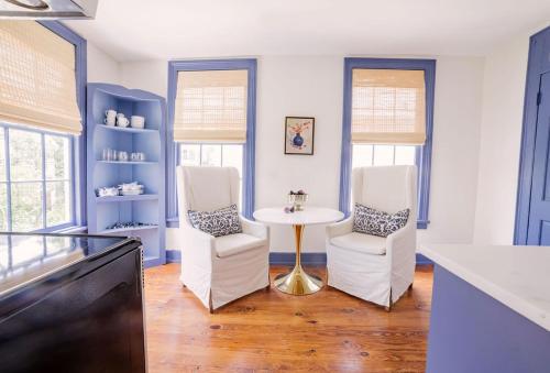 a kitchen with two white chairs and a table at Guesthouse Charleston EAST 42 C in Charleston