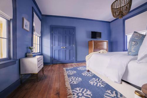 a blue bedroom with a bed and a blue wall at Guesthouse Charleston EAST 42 C in Charleston