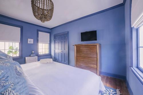 a blue bedroom with a bed and a tv at Guesthouse Charleston EAST 42 C in Charleston