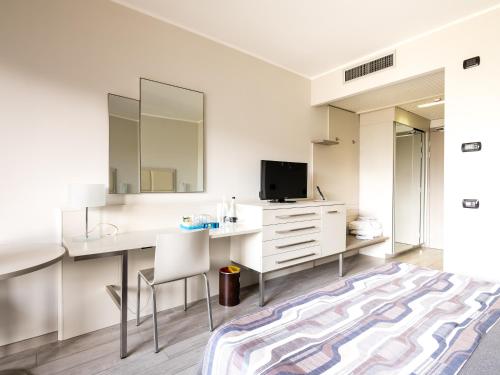 a white room with a desk and a tv at Parc Hotel in Peschiera del Garda