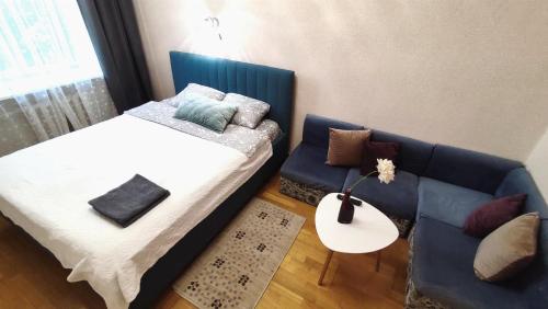a bedroom with a bed and a couch and a table at Kremlyovskaya Apartament in Vladimir
