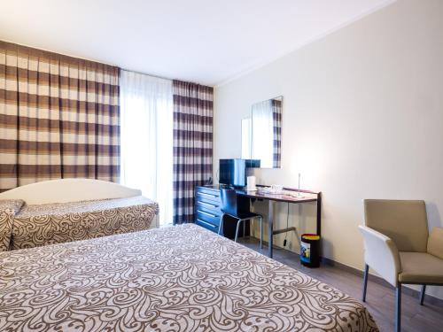 a bedroom with a bed and a desk and a chair at Parc Hotel in Peschiera del Garda