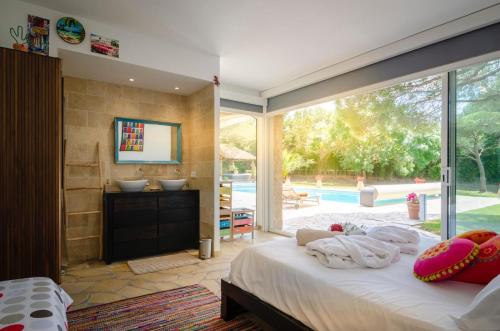 une chambre avec un lit et une grande fenêtre en verre dans l'établissement Villa Siena, à Roquebrune-sur Argens