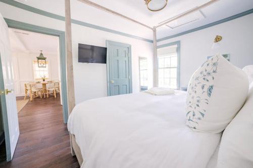 a bedroom with a white bed and a dining room at Guesthouse Charleston EAST 42 D in Charleston