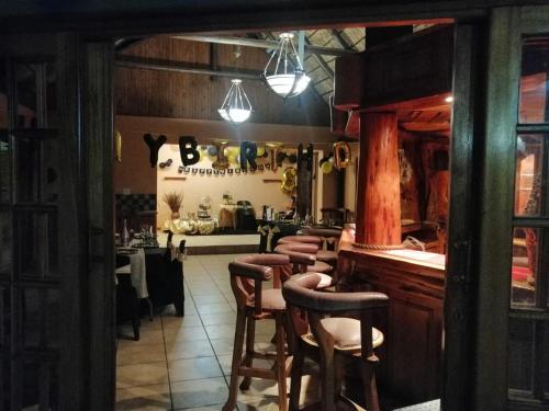 un bar con una fila de taburetes en un restaurante en NTUMBA VILLA, en Vereeniging