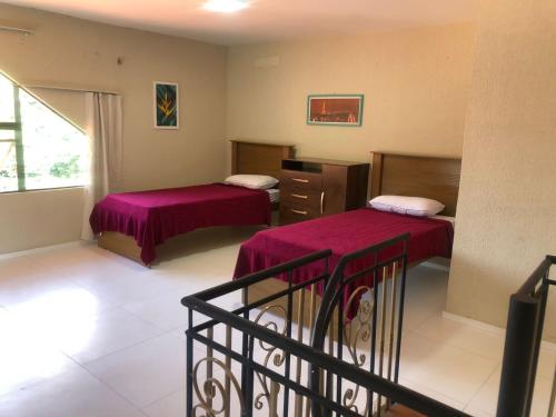 a hotel room with two beds and a balcony at Dei Fiori Guaramiranga in Guaramiranga