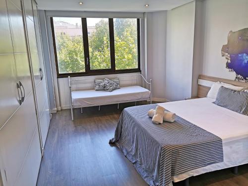 Habitación pequeña con 2 camas y ventana en Apartamento Boulevard Gran Capitan by JITKey, en Córdoba