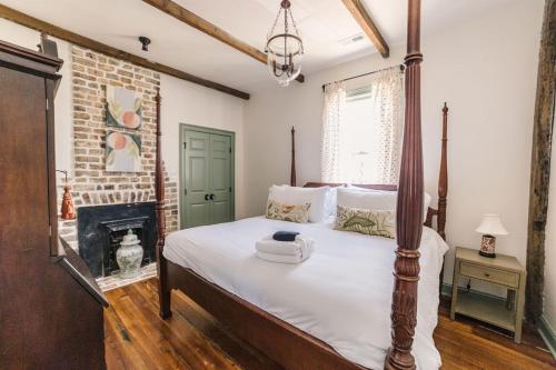 a bedroom with a large bed with a fireplace at Guesthouse Charleston EAST 44 in Charleston