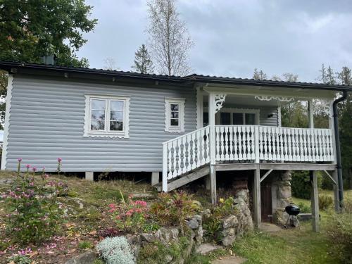 a small blue house with a porch and a balcony at Berget in Skillingaryd