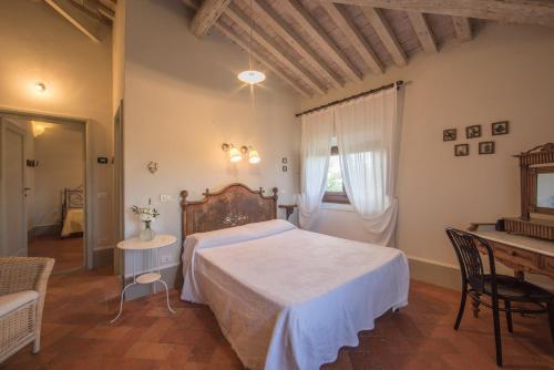 a bedroom with a bed and a table and a window at Villa Teresa in Cavriglia