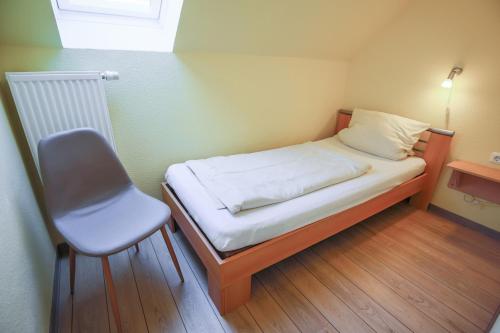SahrensdorfにあるFerienhof Büdlfarm - Nischeの小さな部屋に小さなベッドと椅子があります。