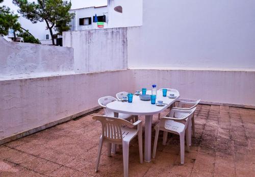 einen weißen Tisch und Stühle auf einer Terrasse in der Unterkunft FLH Monte Gordo Family Flat with Terrace in Monte Gordo