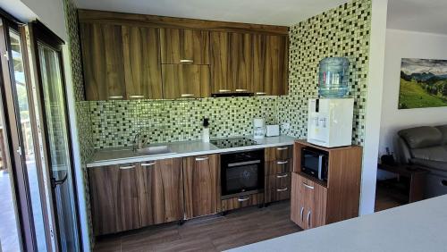 a kitchen with wooden cabinets and a sink and a microwave at Vila Pestera in Peştera
