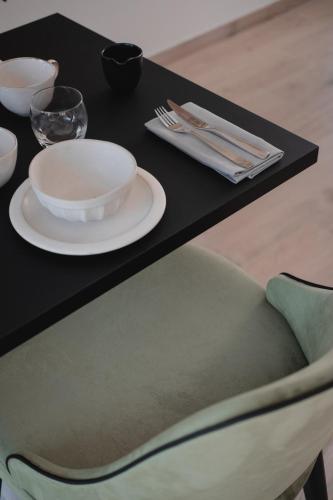 a black table with a plate and a chair at Hôtel-Restaurant Villa Métis in Les Herbiers