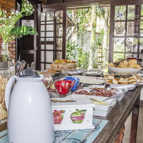 a table with a buffet of food on it at Pousada Dunas da guarda in Guarda do Embaú