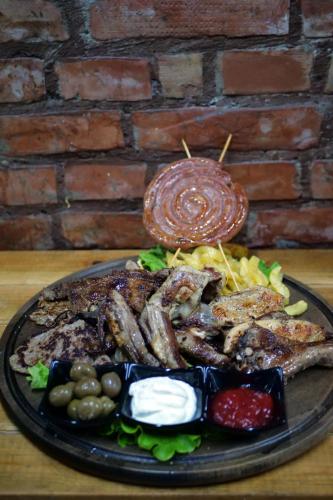 a plate of food with meat and vegetables on a table at Bujtina e Muriqit in Shkodër